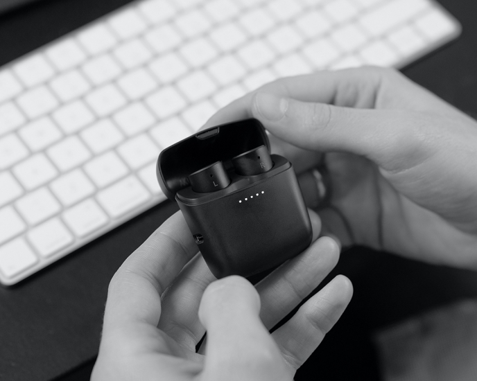 black and white image of hands holding melomania earbud case